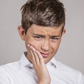 Young man in pain holding cheek