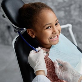 a child patient smiling during her dental checkup