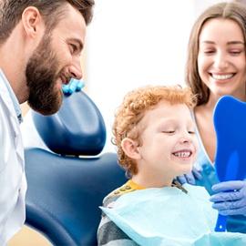 Boy smiling into mirror at dentist office