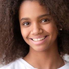 A young female wearing a white shirt and smiling 