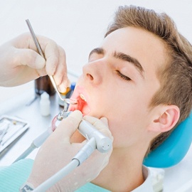 A teenage boy having a tooth-colored filling put into place