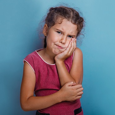 Midland Children's Emergency Dentist Little girl in pain holding cheek