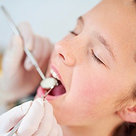 Relaxed child with eyes closed in dental chair