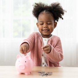 a child putting money in a piggy bank