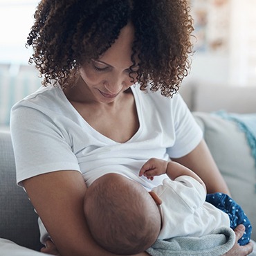 a nursing mother holding her infant