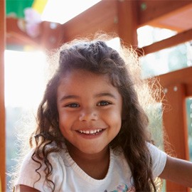 a smiling child playing outside 