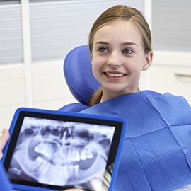 Dentist and patient looking at x-rays on tablet