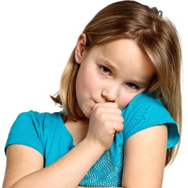 A young girl wearing a blue blouse sucks her thumb
