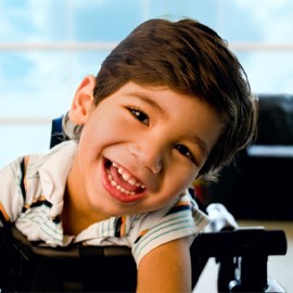 a smiling boy in a wheelchair 
