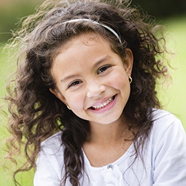 Little girl smiling while playing outside