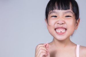 child smiling with tooth in hand