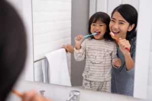 Mother and child brushing teeth