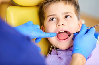 Little boy getting an exam from a pediatric dentist in Midland