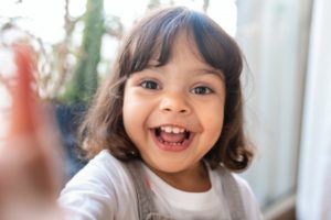 a child laughing and playing in front of a window