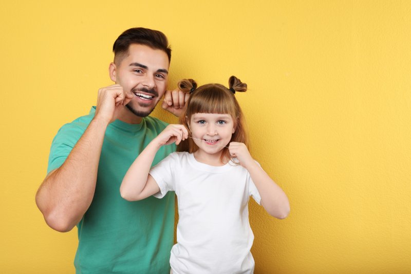 man and child flossing their teeth