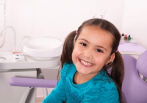 a child smiling while visiting their dentist