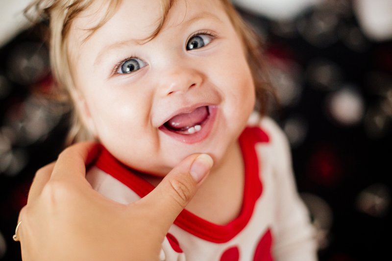 baby smiling with two teeth