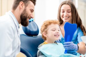 Kid looking into mirror at the dentist's office.