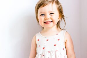 little girl smiling with her tongue slightly out
